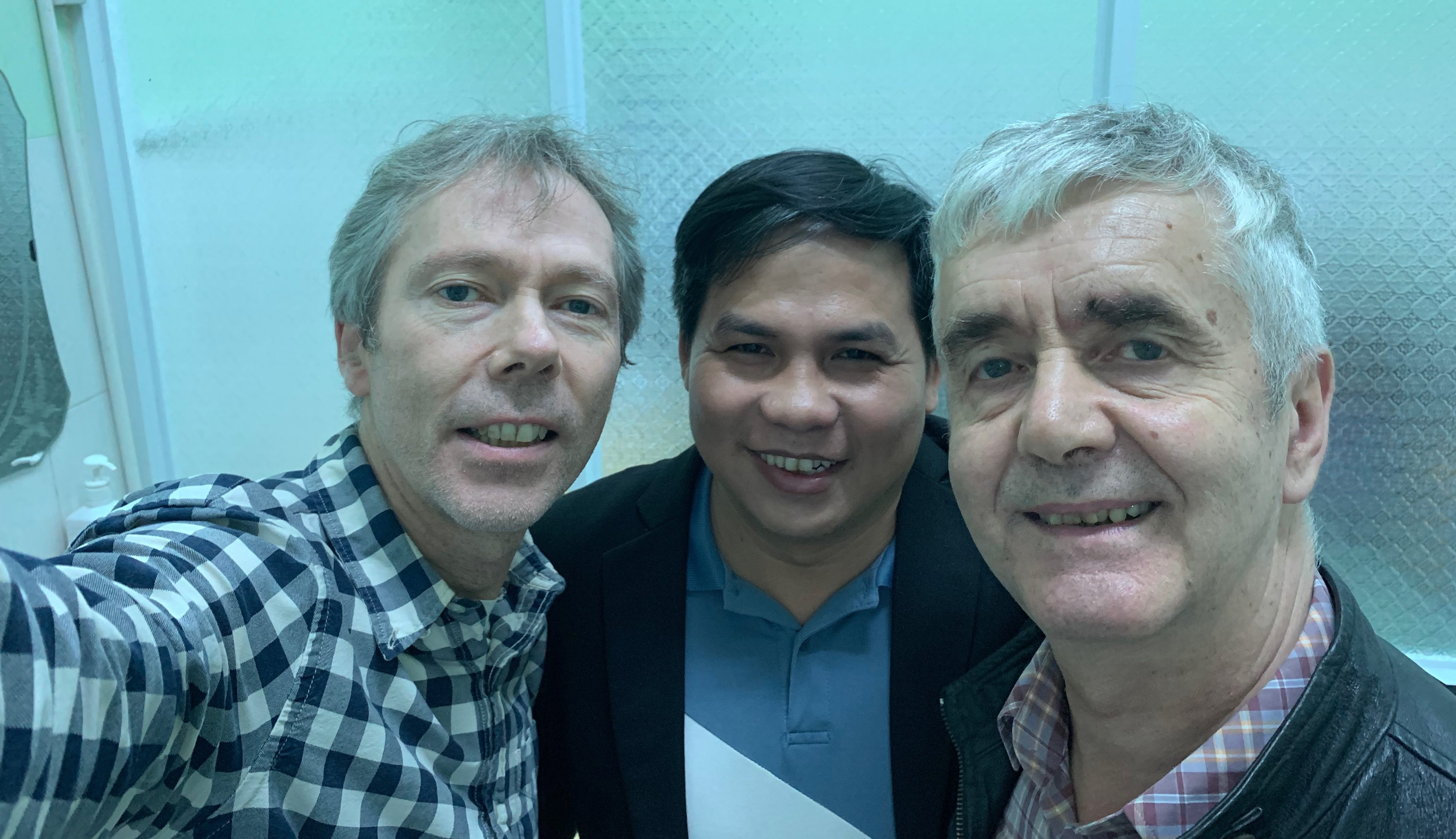Richard Wright with Dr Chinh and Simon Hyde in the hospital, the three of them smiling into a phone camera.